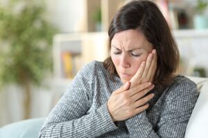 Woman holding jaw in pain